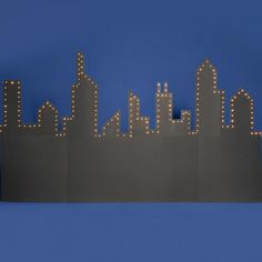 a city skyline with lights in the shape of buildings and skyscrapers on a blue background