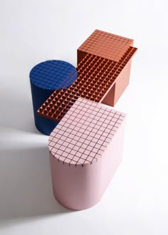 three different colored objects sitting next to each other on a white surface and one is made out of legos