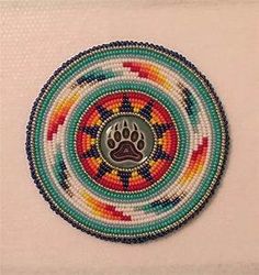 a beaded brooch with a dog's paw in the center on a white background