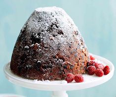 a bundt cake with raspberries on a white plate