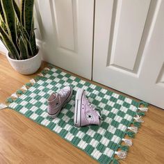 two pairs of shoes sitting on the floor next to a potted plant