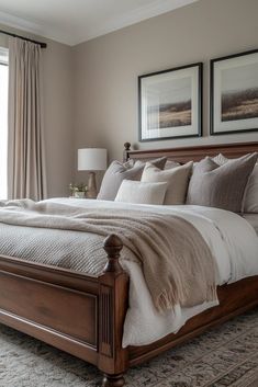 a large bed sitting in a bedroom next to two framed pictures on the wall above it