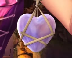 a heart shaped object hanging from a string