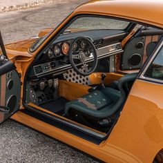 an orange sports car with its door open