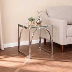 a living room with a couch, chair and glass table on the floor in front of it