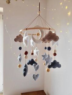 a mobile made out of felt with clouds and stars hanging from it