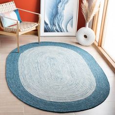 a living room with an area rug and chair next to a painting on the wall