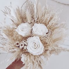 a bouquet of white flowers and feathers on a table