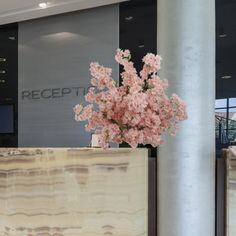 a vase filled with pink flowers sitting on top of a counter