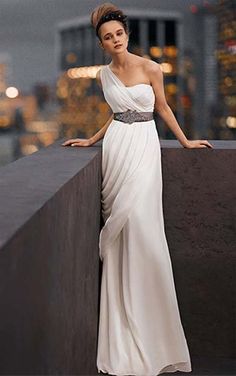 a woman in a white dress leaning on a wall with her hand on her hip