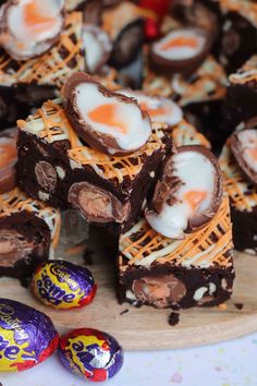 chocolate brownies with eggs and marshmallows on a cutting board next to candy