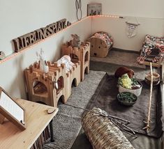 a room filled with lots of wooden toys and decor on the walls, including a cat bed