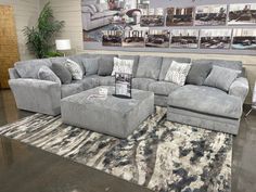 a large sectional couch with matching footstools in a living room setting on a rug