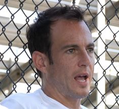 a man standing in front of a chain link fence