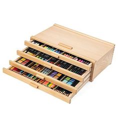 three wooden drawers filled with colored pencils and crayons on the bottom drawer