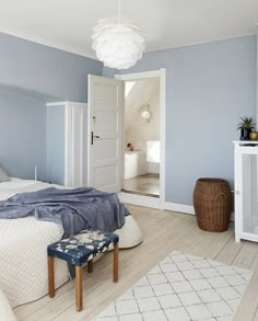 a bedroom with blue walls and white furniture