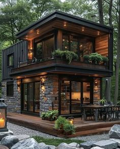 a small house in the middle of some rocks and trees with lights on it's windows