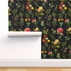 a wallpaper with flowers and leaves on it next to a white door frame in an empty room