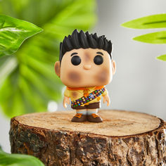 a small figurine sitting on top of a tree stump next to a plant