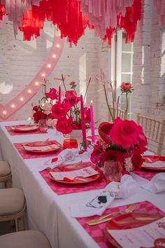 the table is set up with pink and red decorations for valentine's day dinner