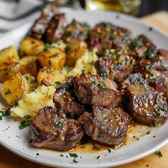 a white plate topped with steak and potatoes