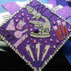 a purple and silver graduation cap decorated with sequins, beads, and scissors