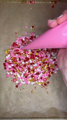 a person is using a pink blow dryer on some sprinkles