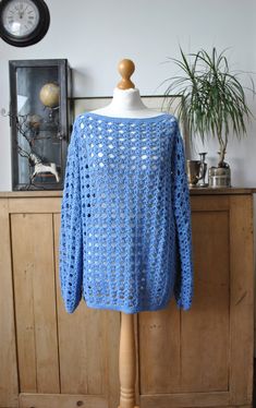 a blue crocheted sweater sitting on top of a mannequin's head