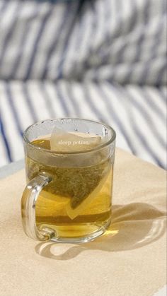 a glass cup filled with tea sitting on top of a table