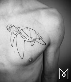 a black and white photo of a man's chest with a turtle tattoo on it