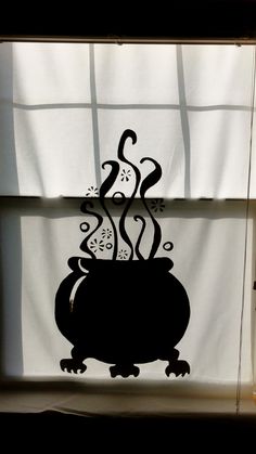 the silhouette of a pot with steam coming out of it on a window sill