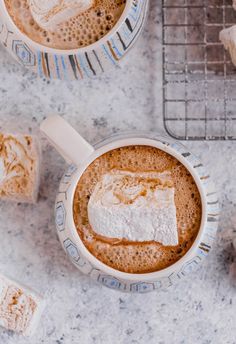 two mugs filled with hot chocolate and marshmallows