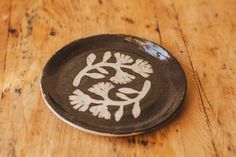 a black and white plate sitting on top of a wooden table