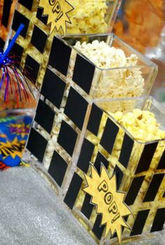 three boxes filled with popcorn sitting next to each other on top of a table covered in confetti