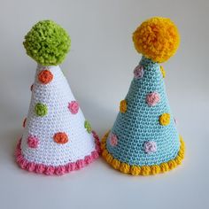 two crocheted party hats with pom poms