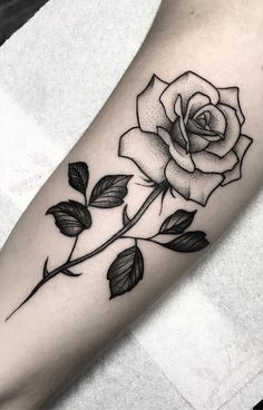 a black and white rose tattoo on the arm