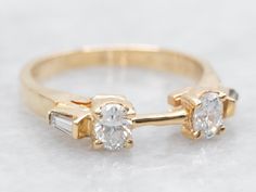 two gold rings with white diamonds on them