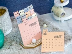 a calendar with cats on it sitting next to other items