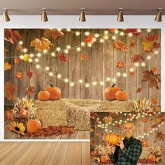 a man holding a pumpkin in front of a wooden wall with fall leaves on it