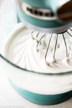 a mixer filled with white cream on top of a counter