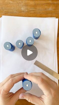 someone is cutting out circles with scissors on top of the paper and making them look like they are spinning