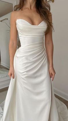 a woman in a white dress posing for the camera