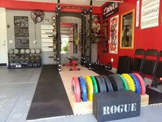 the inside of a gym with rows of different colored plates and barbells in it