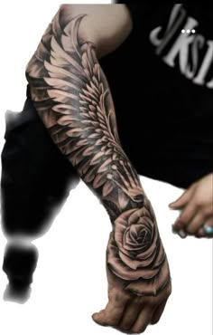 a man's arm with a rose and angel wings tattoo on the left forearm