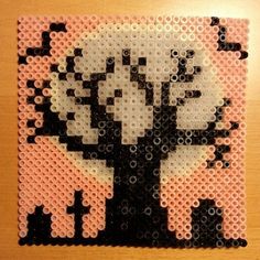 a piece of art made out of legos on a wooden table with the image of a tree