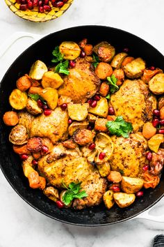 a casserole dish filled with chicken, vegetables and sauce on a blue table cloth