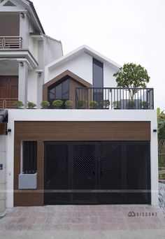 a house with two garages and a balcony