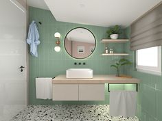 a bathroom with green tiles and a white sink in front of a large round mirror