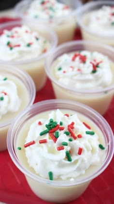 small cups filled with whipped cream and sprinkles on a red tablecloth