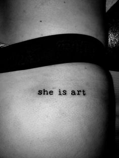 a woman's stomach with the words she is art tattooed on it